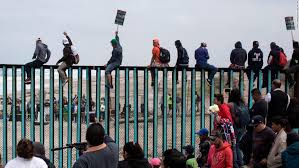 Caravan members climbing the fence.